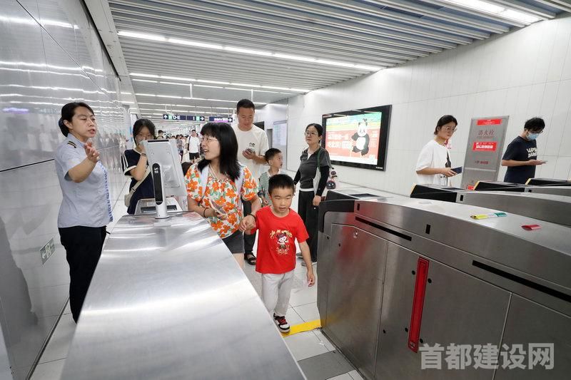 北京地铁站务员引导带孩子的乘客从宽闸机出站
