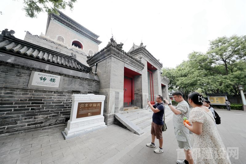于钟鼓楼广场的北京中轴线世界文化遗产标志碑亮相，游人纷纷拍照留念