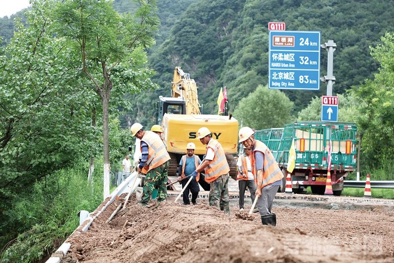 7 月28 日，在怀柔区琉璃庙镇柏查子村，北京建工养护集团正在抢通国道111(京漠线）